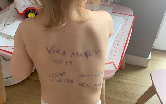 Mãe ucraniana escreve dados pessoais nas costas da filha com medo da guerra