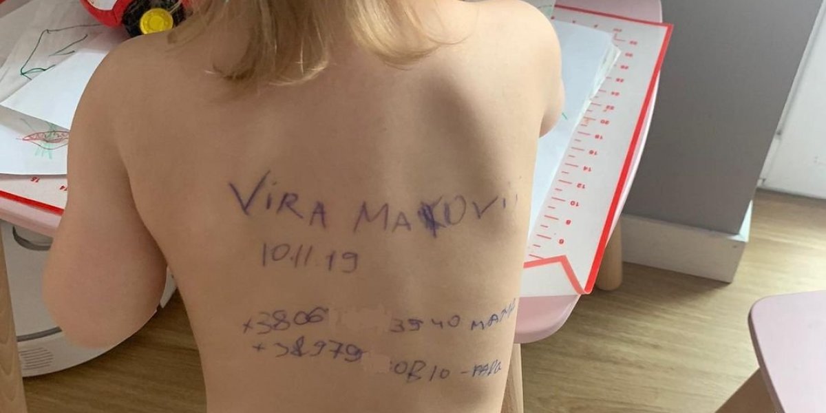 Mãe ucraniana escreve dados pessoais nas costas da filha com medo da guerra