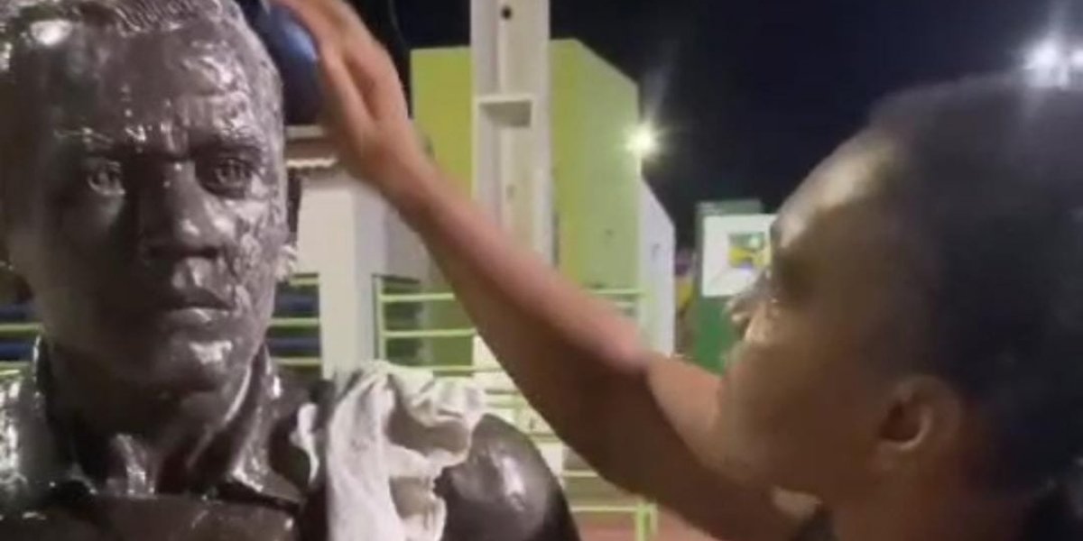 Prima de Daniel Alves faz limpeza da estátua pichada em Juazeiro