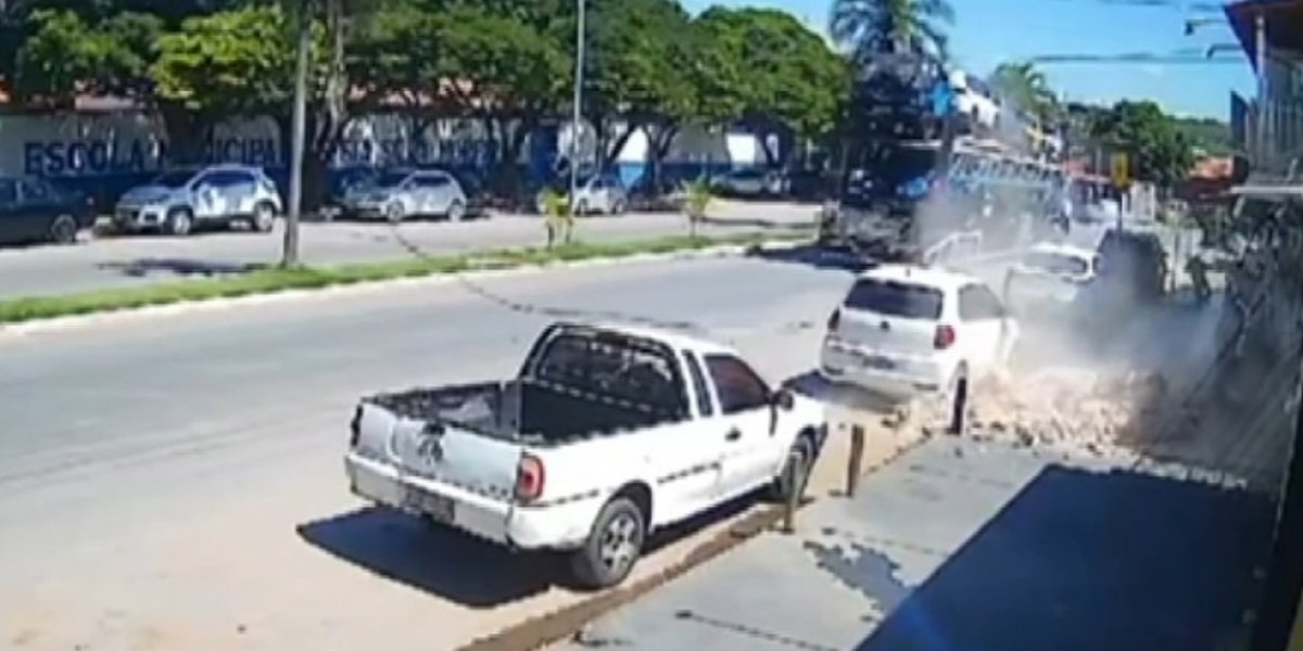 Caminhão-cegonha derruba fachada de loja após esbarrar em fiação elétrica