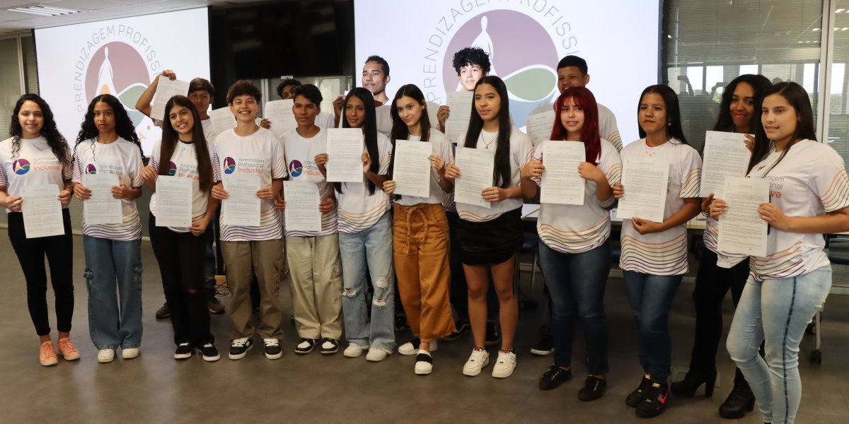 Estudantes que fazem parte do jovem aprendiz, possa para foto com o contrato de trabalho, durante o lançamento do Programa de Aprendizagem Profissional Inclusiva (API) voltado à juventude migrante do Distrito Federal