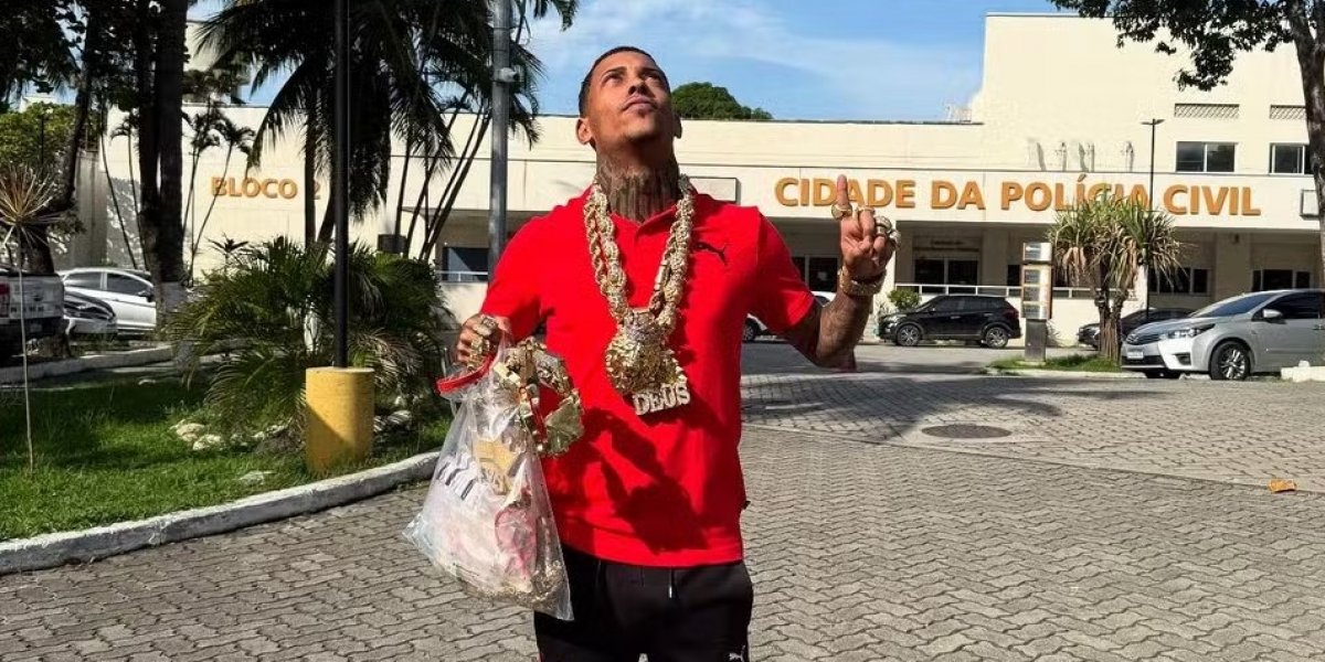MC Poze do Rodo em frente a delegacia segurando os itens recuperados