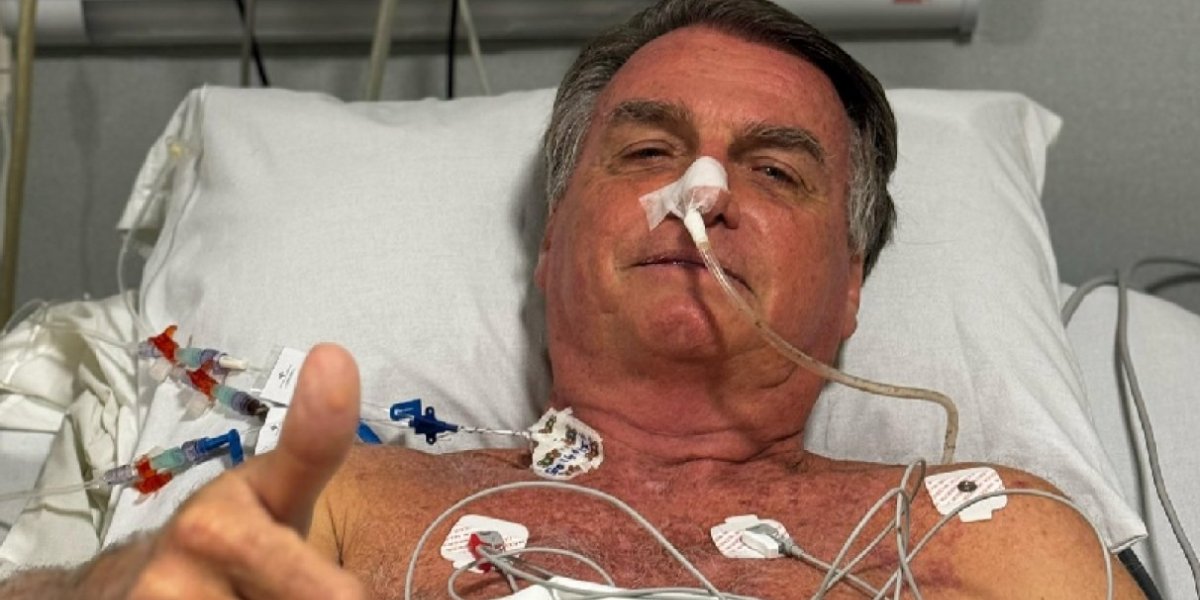 A imagem mostra o ex-presidente Jair Bolsonaro no leito do hospital sorrindo e dando um legal