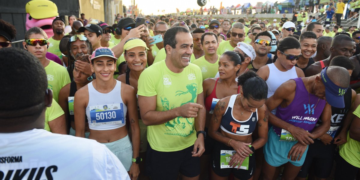A imagem mostra o prefeito Bruno Reis com vários atletas durante a corrida Salvador 21k