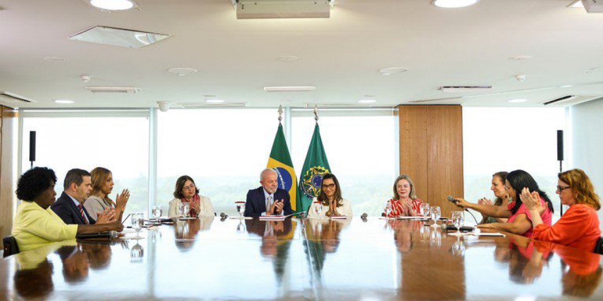 Lula, Janja e ministros na mesa na sede do governo comentando sobre a Lei