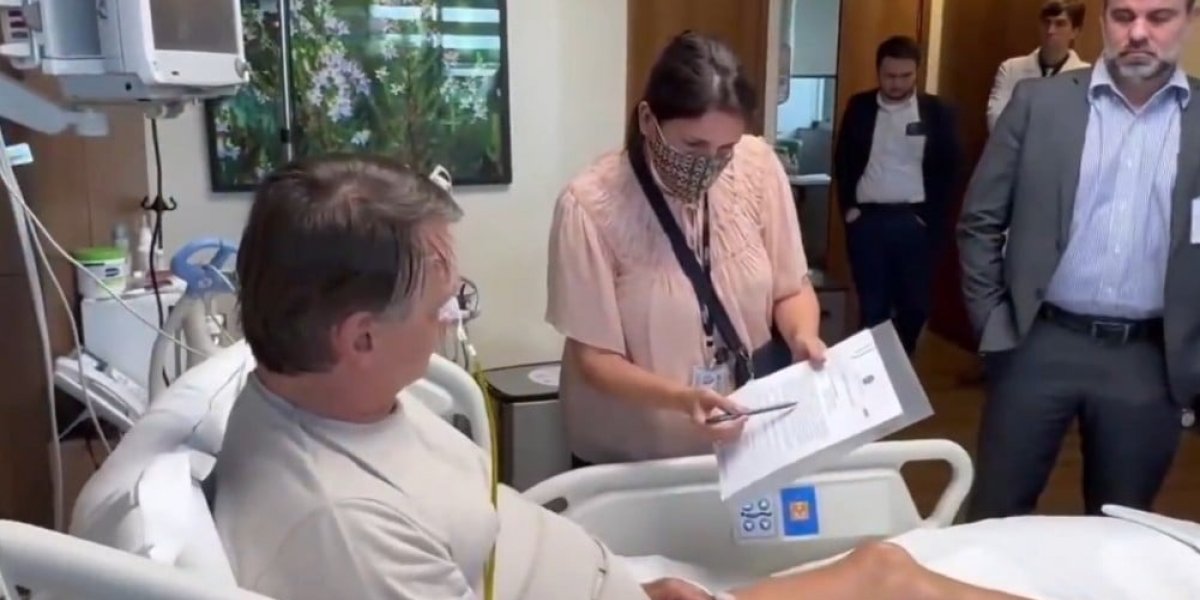 A imagem mostra o ex-presidente Bolsonaro sendo intimado no hospital