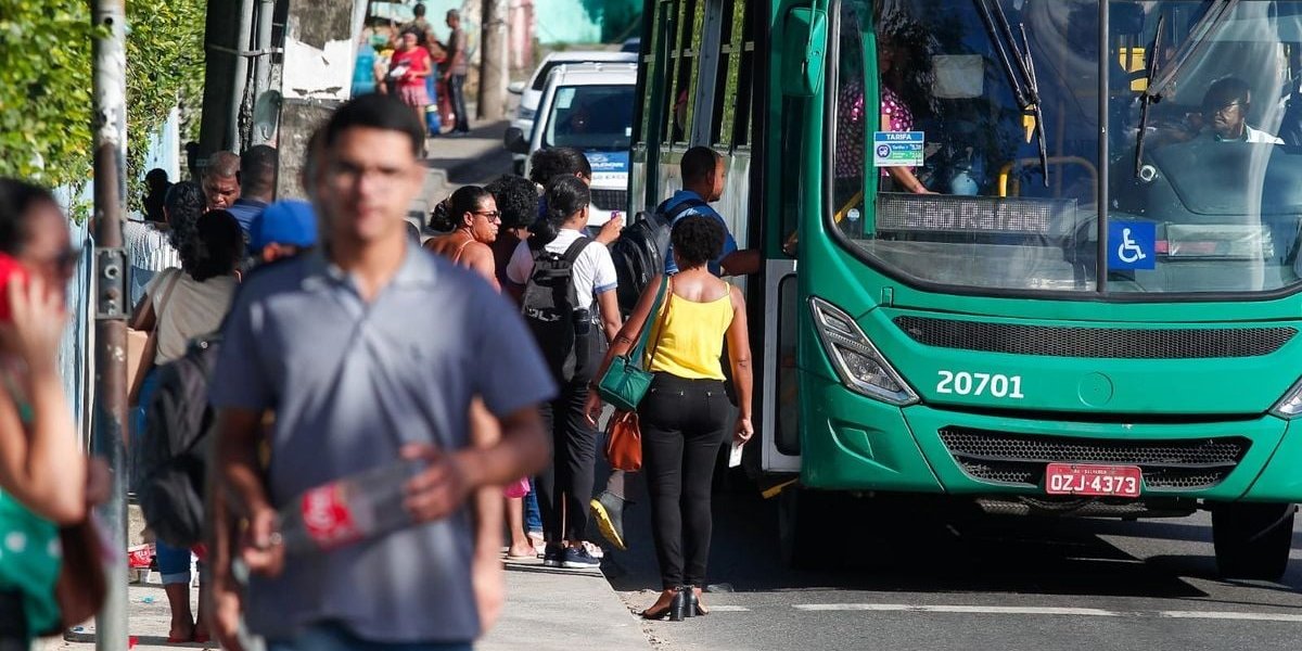 A imagem mostra passageiros acessando um ônibus de Salvador