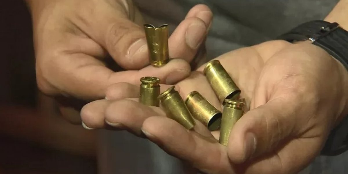 A imagem mostra capsulas de balas na mão de um agente