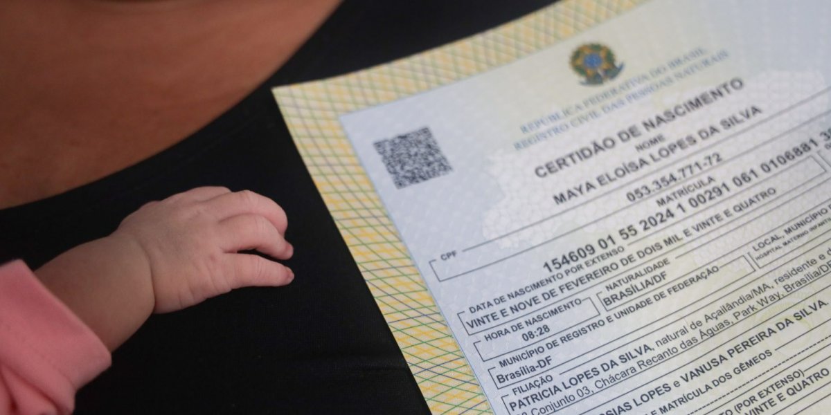 Certidão de nascimento ao lado de uma criança