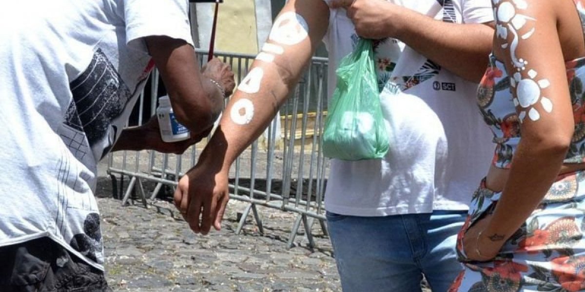 A imagem mostra a pintura corporal em turistas