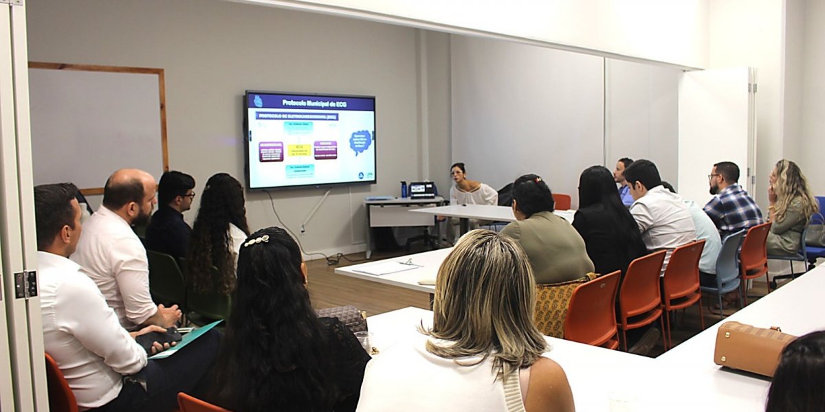 A imagem mostra uma reunião com profissionais de saúde