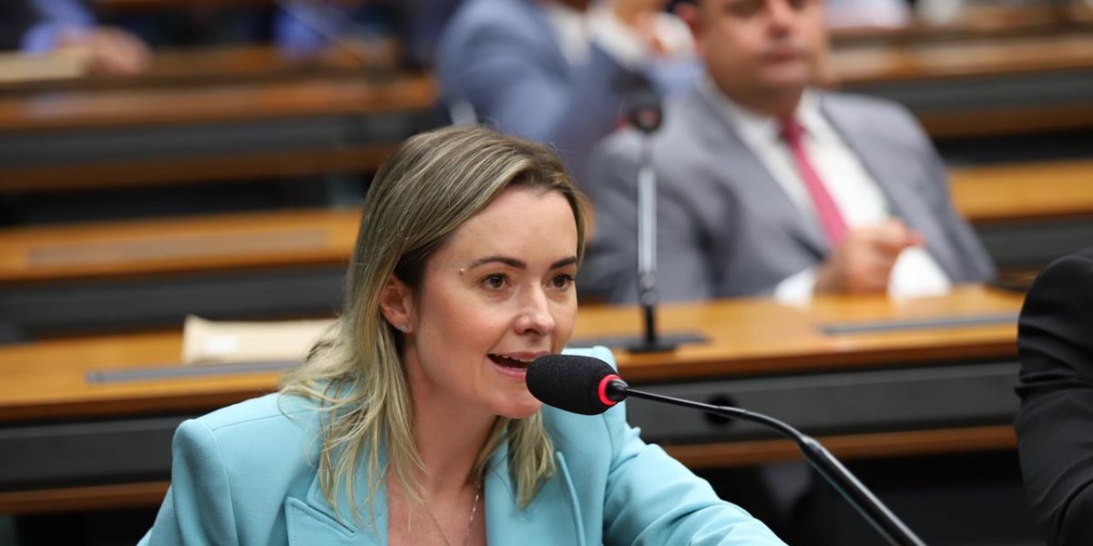 Deputada falando ao microfone na Câmara