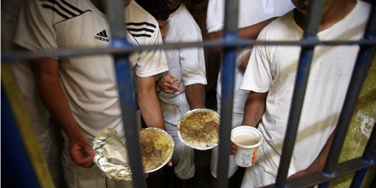 Presos segurando marmitas