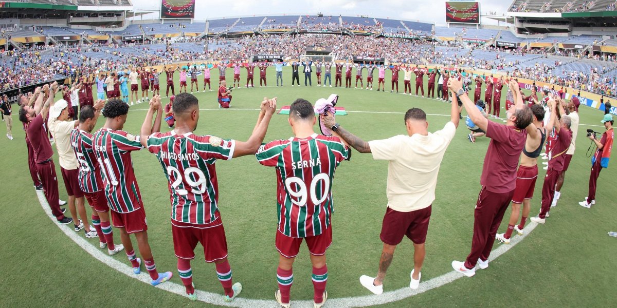 Elenco e comissão técnica rezando após jogo
