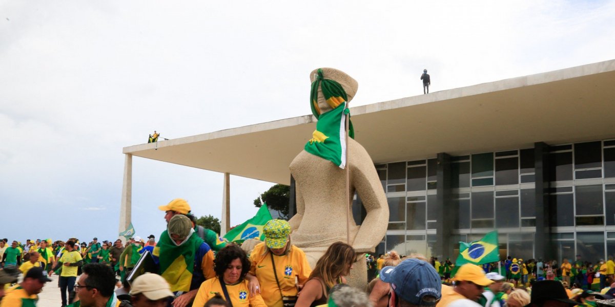 Pessoas em cima da estátua da Justica, no Palácio do Planalto, durante o atentado de 8 de janeiro de 2023