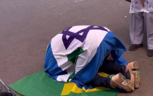 Apoiador de Bolsonaro faz oração em frente ao condomínio do ex-presidente, durante julgamento
