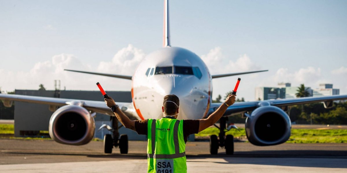 Funcionário orientando manobra de avião no aeroporto de Salvador