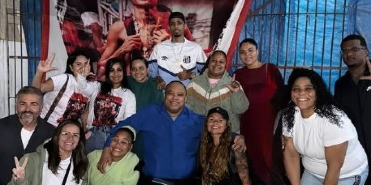 De roupas e boné preto, Fernanda Valença aparece ao lado de religiosos e fãs do cantor