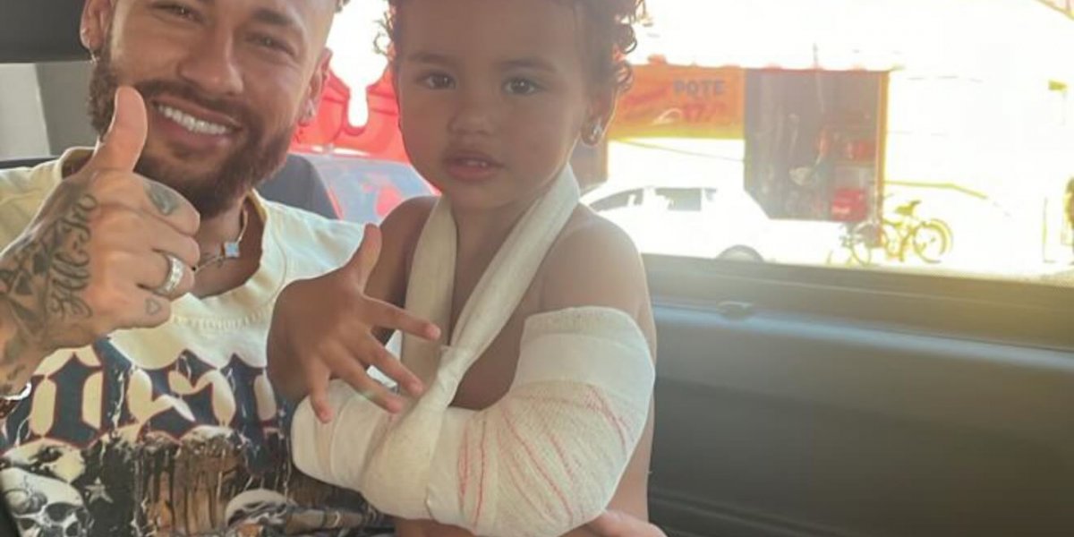 Neymar com a filha de braço machucado no colo