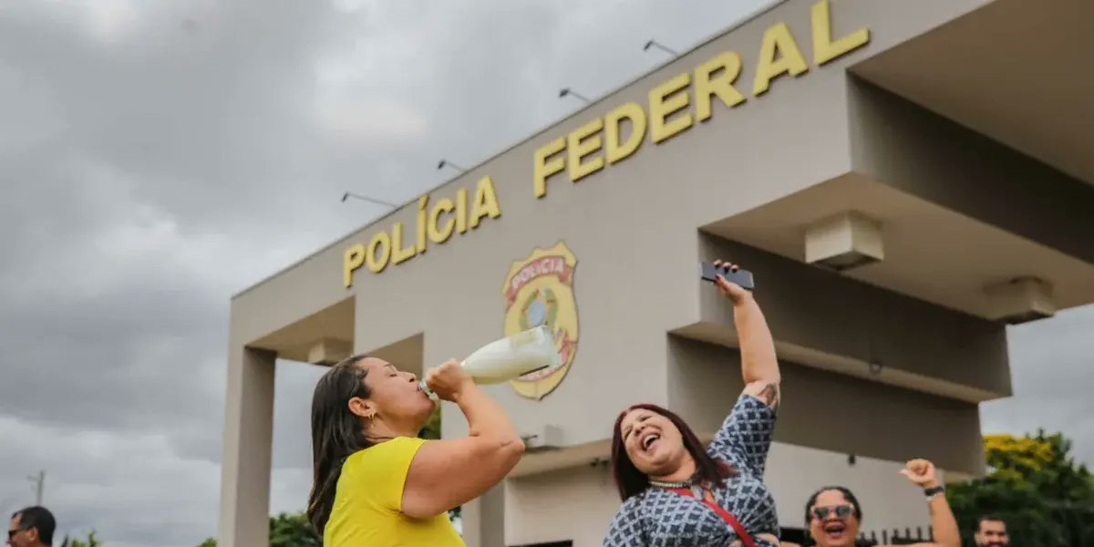 Pessoas celebram a prisão do ex-presidente Jair Bolsonaro em frente ao prédio da PF no Distrito Federal