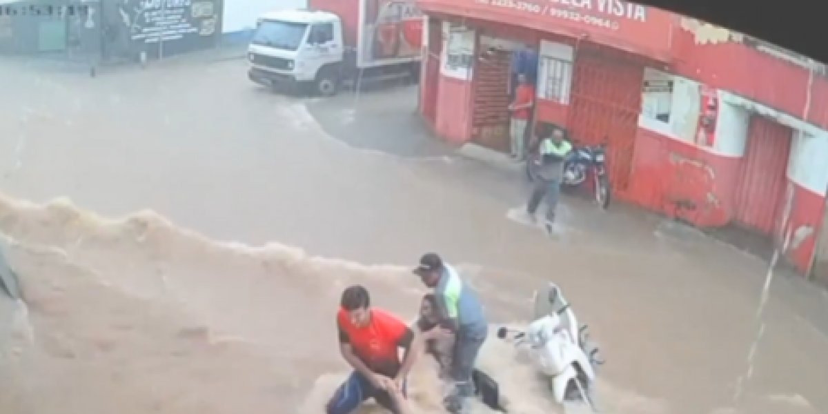 Duas mulheres e uma motocicleta são arrastadas durante tempestade