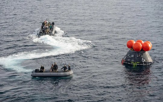 Equipe de resgate ao lado da cápsula de pouso