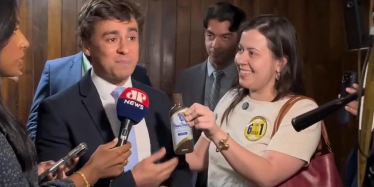 Nikolas Ferreira é presenteado com óleo de peroba pela deputada Sâmia Bomfim
