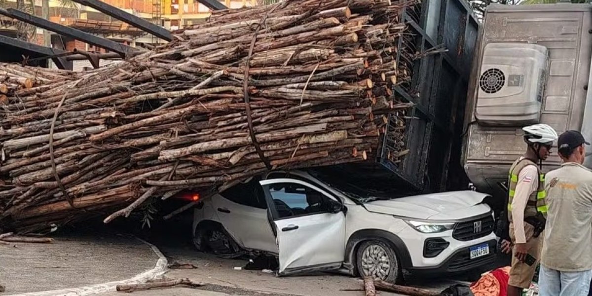 Carga de madeira cai de caminhão, esmaga carro e deixa um ferido em Pituaçu