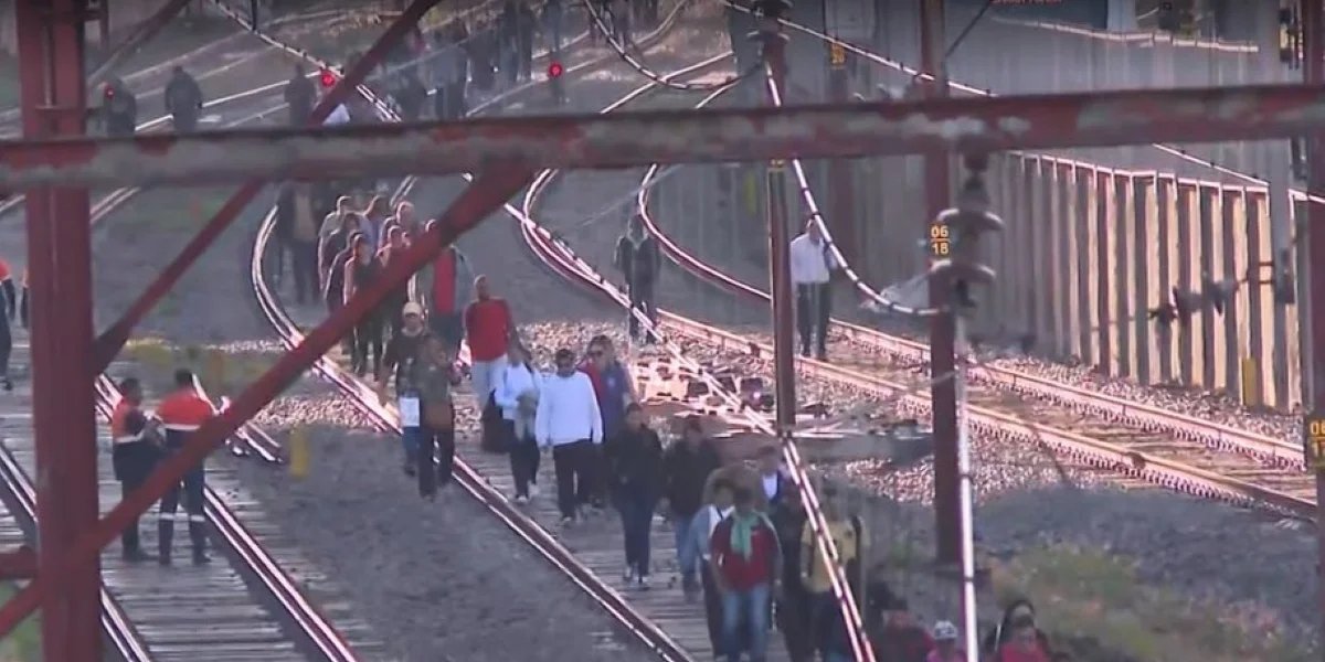 Passageiros caminham pelos trilhos após paralisação de linhas de trem em São Paulo