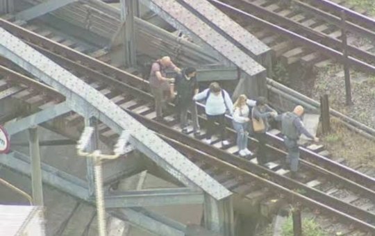 Policiais auxiliam passageiros a saírem dos trilhos do trem em São Paulo após falha na operação